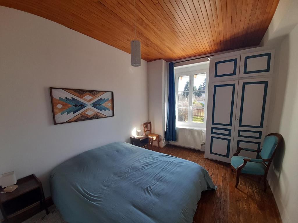 ein Schlafzimmer mit einem blauen Bett und einem Fenster in der Unterkunft Avol d'oiseau in Villers-Farlay