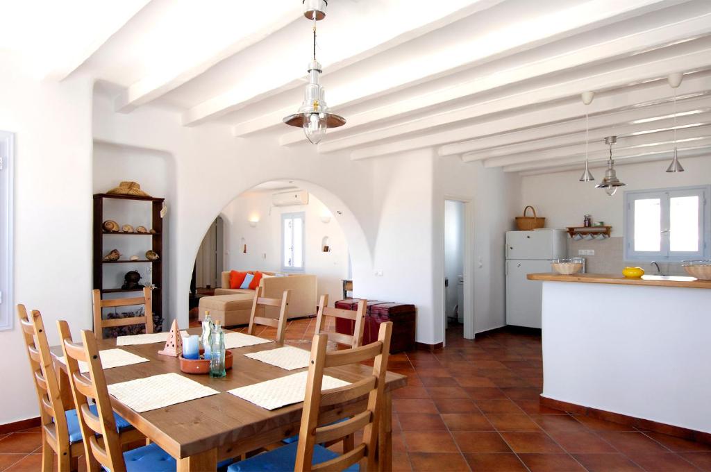 a dining room and kitchen with a table and chairs at Divers House Paros in Ambelas