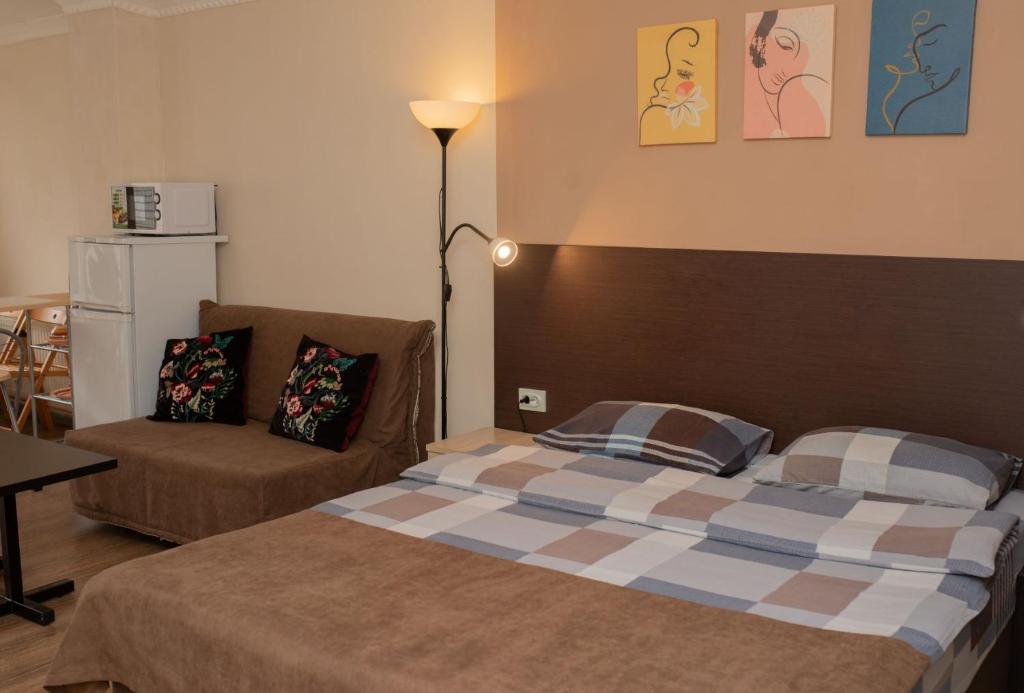 1 dormitorio con 1 cama y 1 silla en Центральный гостевой дом, en Novorossiysk