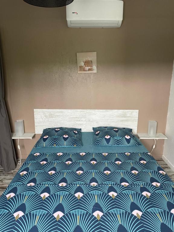 uma cama com um edredão azul e branco num quarto em Villas Smoothie Papaya em Le François
