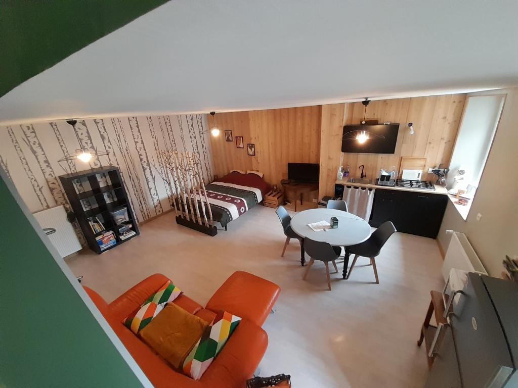 - un salon avec un canapé et une table dans l'établissement Studio Cosy de 2 à 4 personnes au cœur du Haut Doubs, entre les lacs, les montagnes et les vignobles, à Frasne