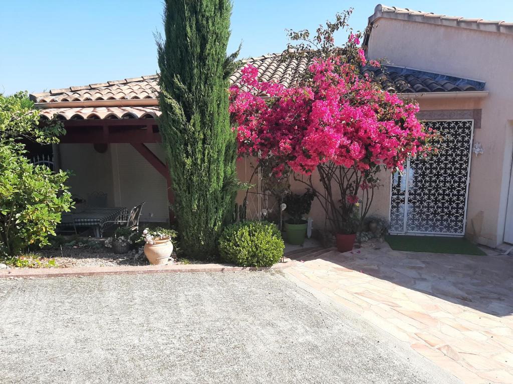 uma casa com flores cor-de-rosa e uma cerca em Chambre d'hote Casa Tozza em Porticcio