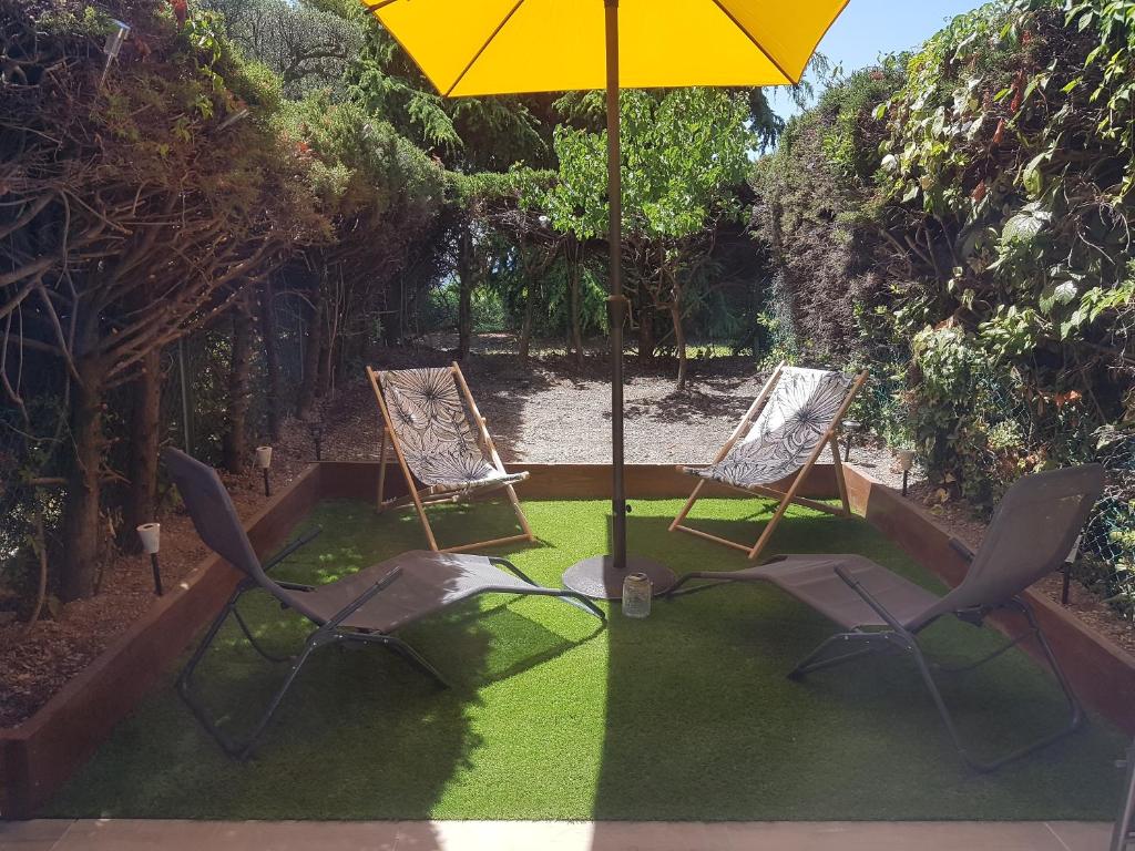 dos sillas y un paraguas en un patio en Studio Le Pénéqué des Anges, en La Ciotat