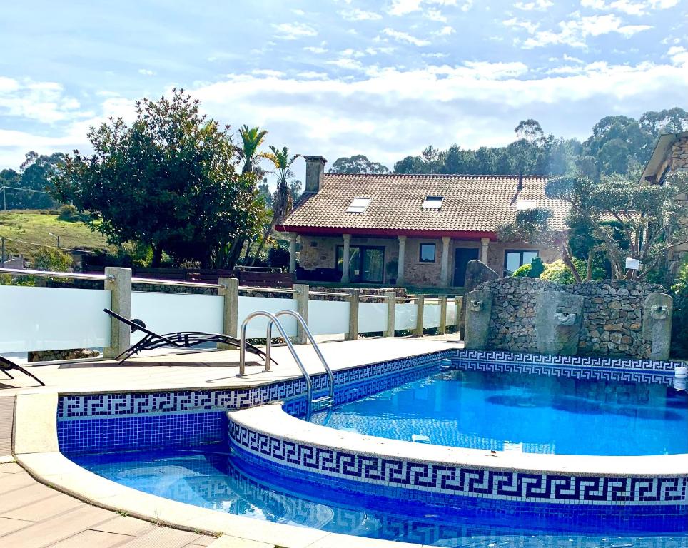 ein Pool vor einem Haus in der Unterkunft VILLA RAICES. Agradable casa con piscina in Baiona