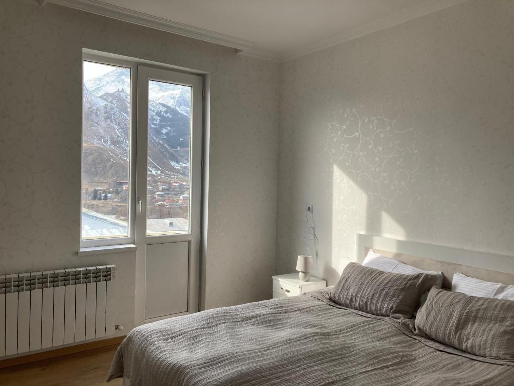 a bedroom with a bed with a view of a mountain at MOUNTAIN HEART in Stepantsminda