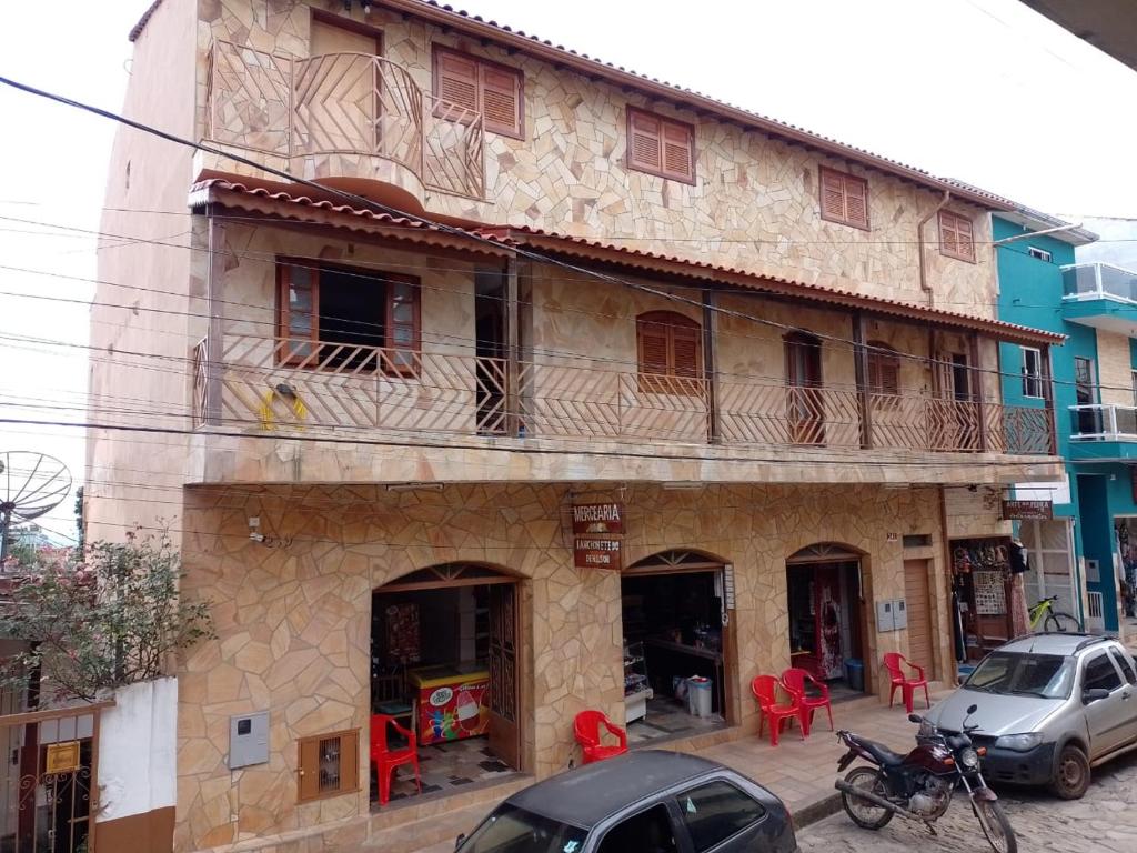 un edificio antiguo con 2 balcones en una calle en Pousada Pedra Encantada, en São Thomé das Letras