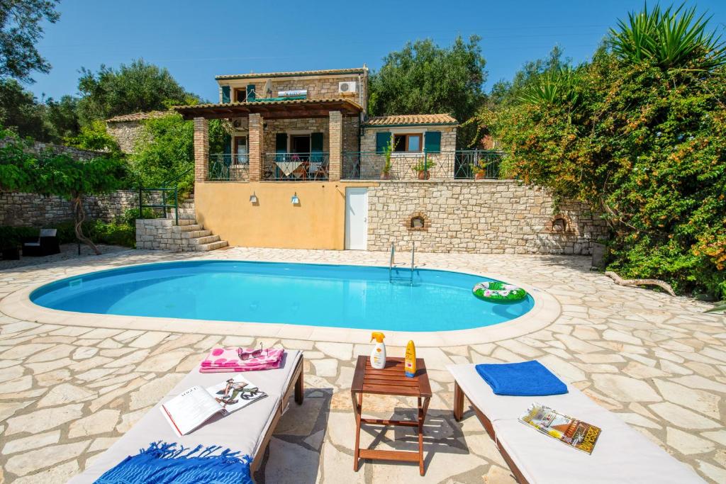 a house with a swimming pool in front of a house at Villa Elia, ,Platanos, Paxos in Koútsion