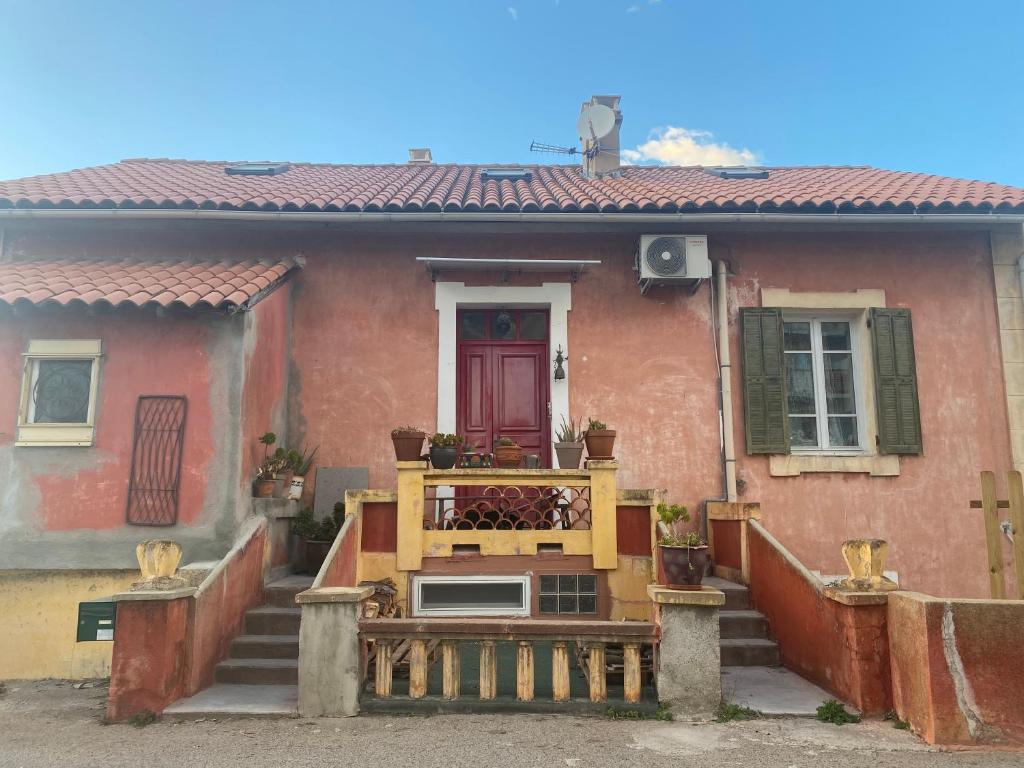 een huis met een veranda met een bankje ervoor bij Mamma-Mia in Calvi