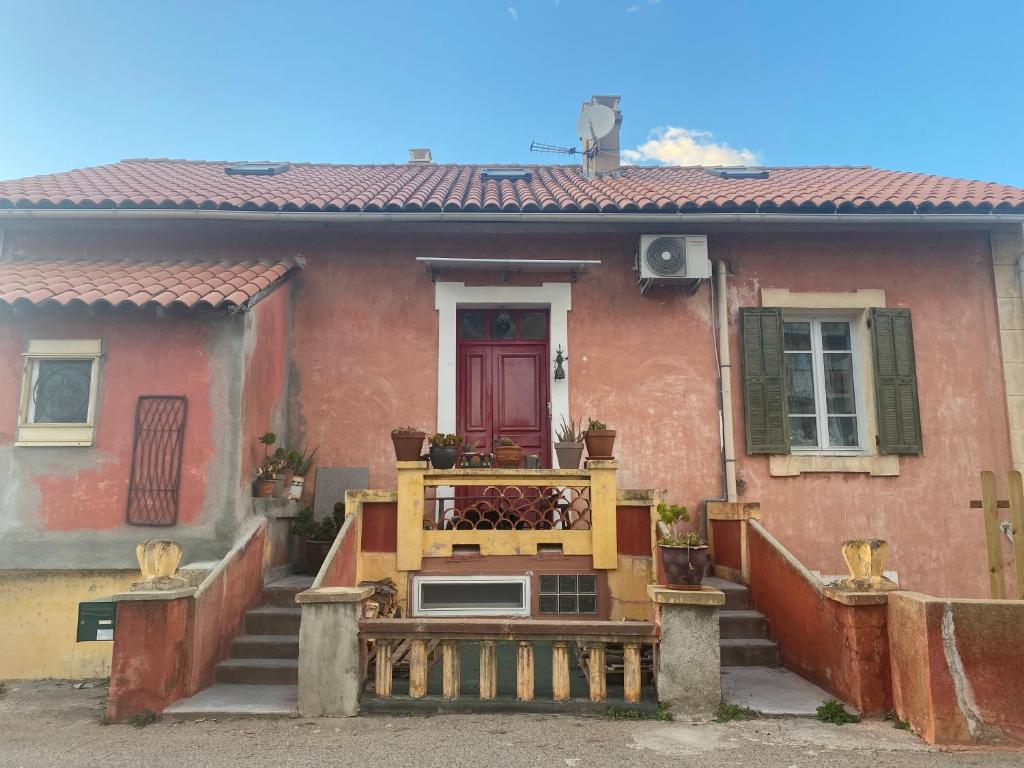 une maison avec une terrasse couverte et un banc devant elle dans l'établissement Mamma-Mia, à Calvi