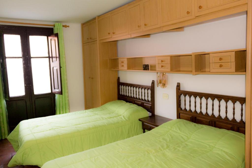 2 camas en una habitación con sábanas verdes en Casa Blascosanz - piso para 6 personas en el pirineo en Hecho