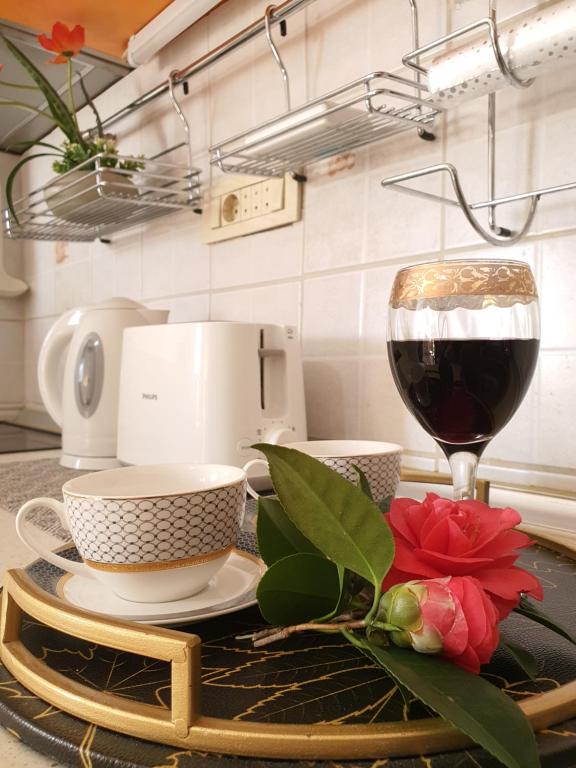 un tavolo con un bicchiere di vino rosso e una macchinetta del caffè di Lalovina Apartment a Herceg-Novi
