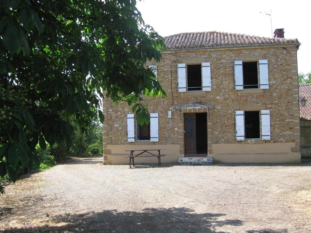 a brick house with a picnic table in front of it at Maison de campagne Les Chênes. in Panjas