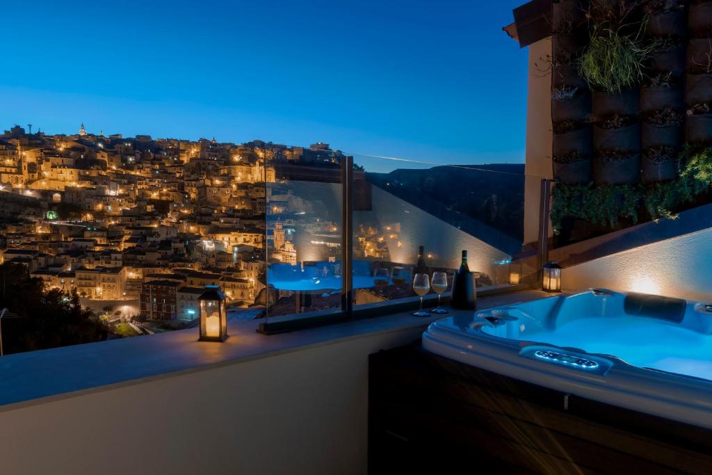 a bathroom with a view of a city at night at Dimora Bonafede Ibla Design Rooms in Ragusa