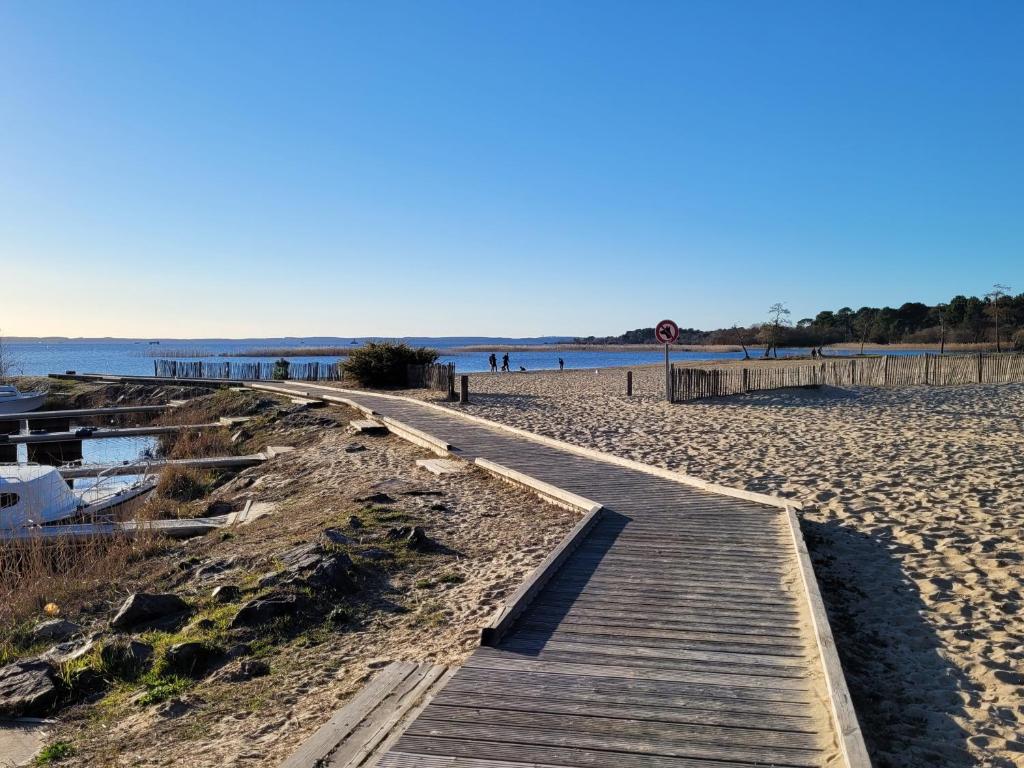a wooden boardwalk on a beach next to the water at Mobil Home Plage Lac Parentis/Biscarosse in Parentis-en-Born