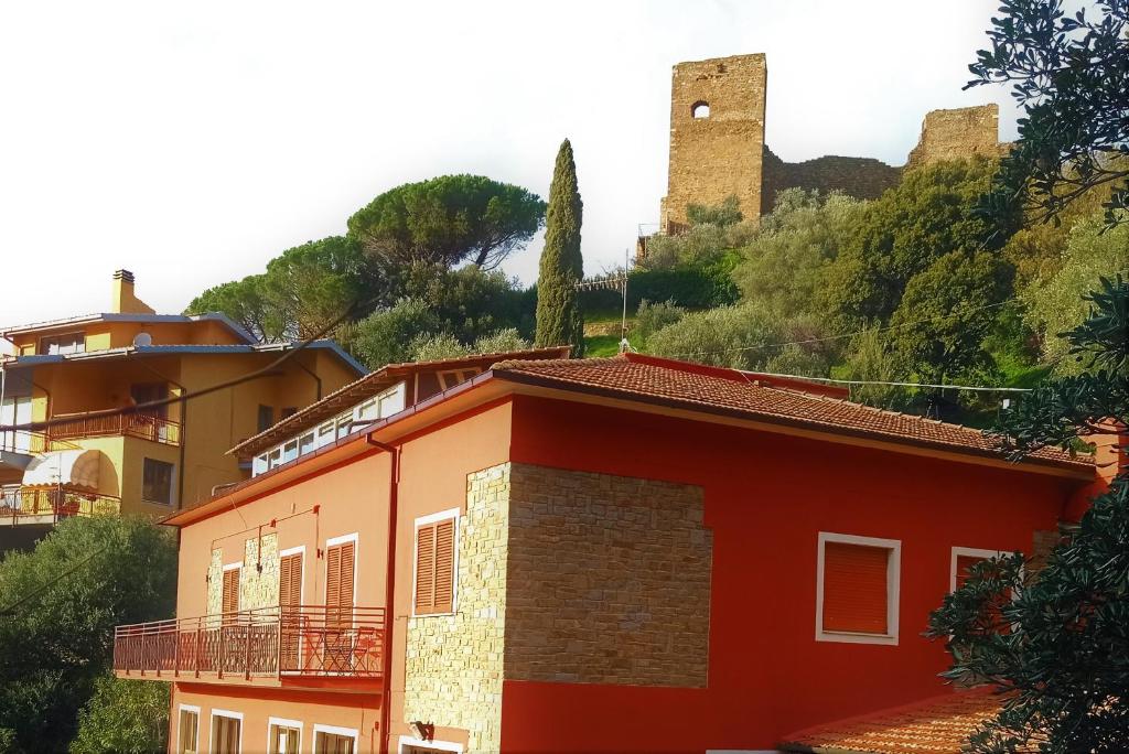 a red building with a castle in the background at ROMANTICA TOSCANA in Scarlino