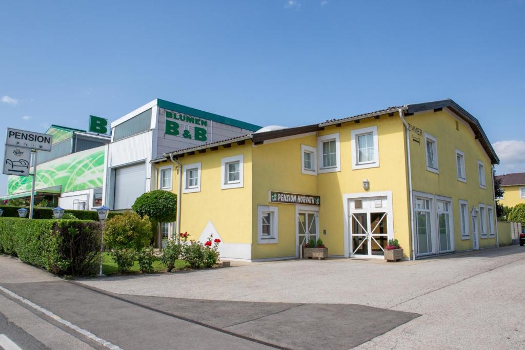 a yellow building on the side of a street at Pension Horvath jun. in Guntramsdorf