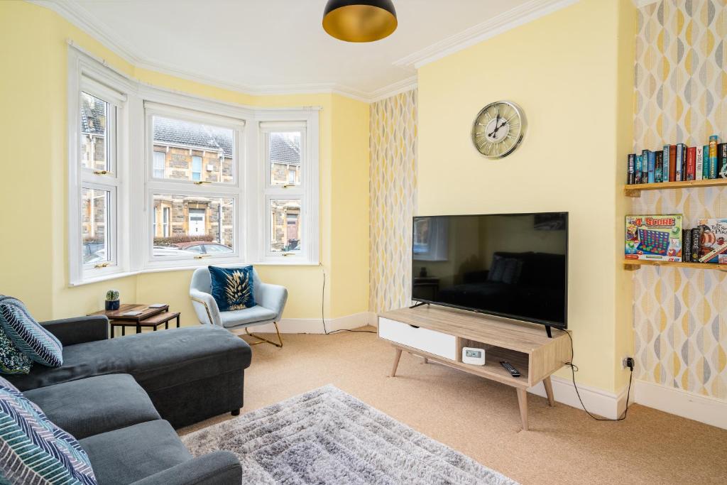 a living room with a couch and a flat screen tv at Fantastic, Spacious 3 Bedroom House With Garden in Bath