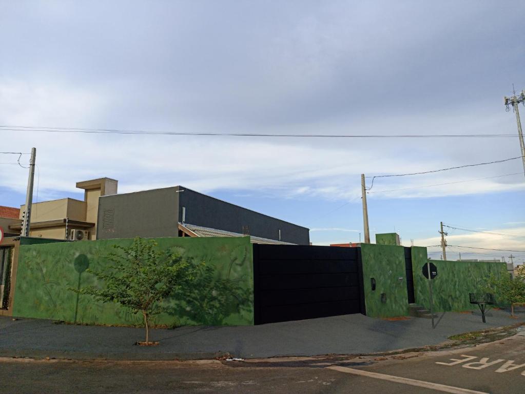 um edifício com uma parede verde ao lado de uma rua em Kitnets RECANTO MAGRO em Olímpia