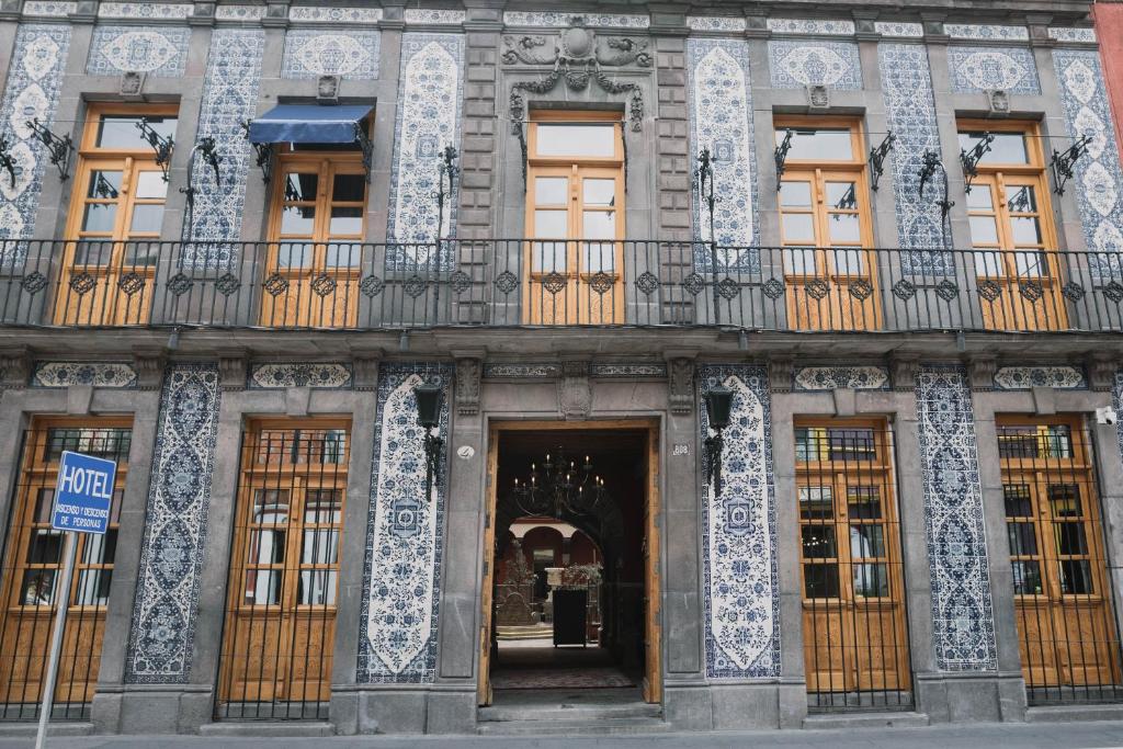 un bâtiment décoré avec une porte et un balcon dans l'établissement Casa Azulai Puebla Hotel Boutique, à Puebla