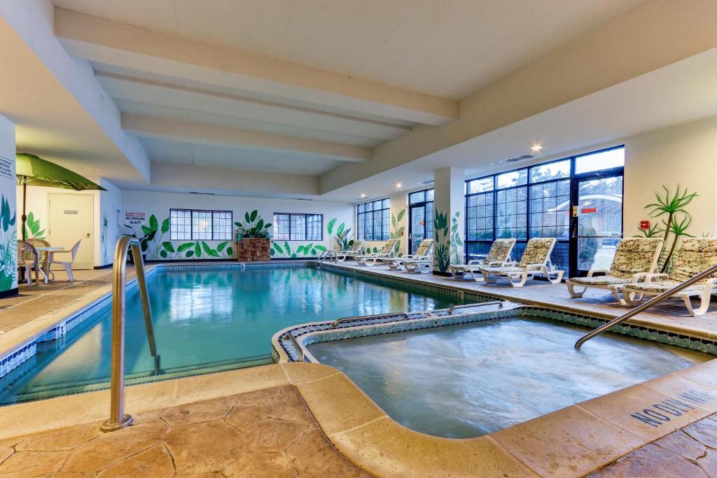 a swimming pool in a hotel room with lounge chairs and a pool at Parkshore Resort in Traverse City