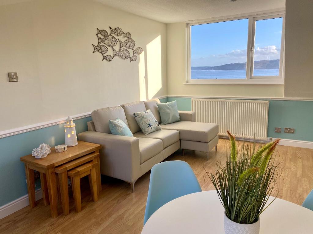 uma sala de estar com um sofá e uma mesa em Lighthouse View, one min from harbour & beach em Scarborough