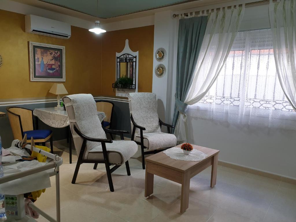 sala de estar con sillas, mesa y ventana en Precioso Estudio en Arroyo de la Miel . Centro, en Benalmádena