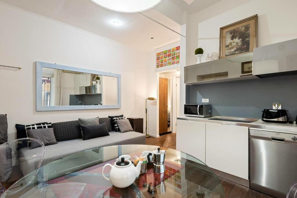 ein Wohnzimmer mit einem Sofa und einem Glastisch in der Unterkunft Pop Corn House in Rom
