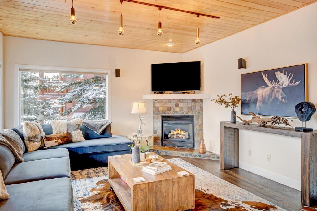 a living room with a blue couch and a fireplace at Luxury Slopeside Condo #97A Next to Ski Resort With Hot Tub & Great Views - 500 Dollars Of FREE Activities & Equipment Rentals Daily in Winter Park