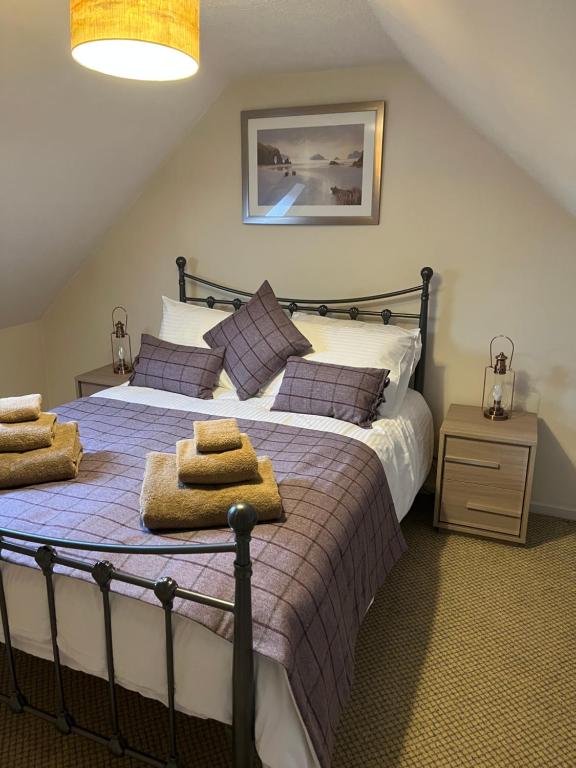 1 dormitorio con 1 cama grande y toallas. en Traditional 2 bed croft, en Portskerra