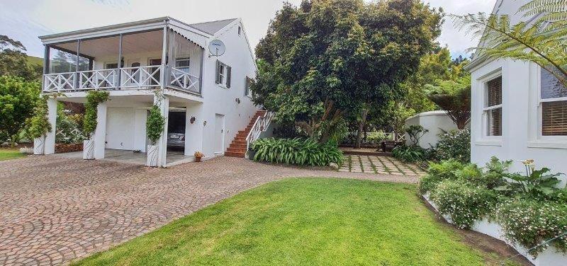 a white house with a porch and a yard at Belvidere102 in Knysna