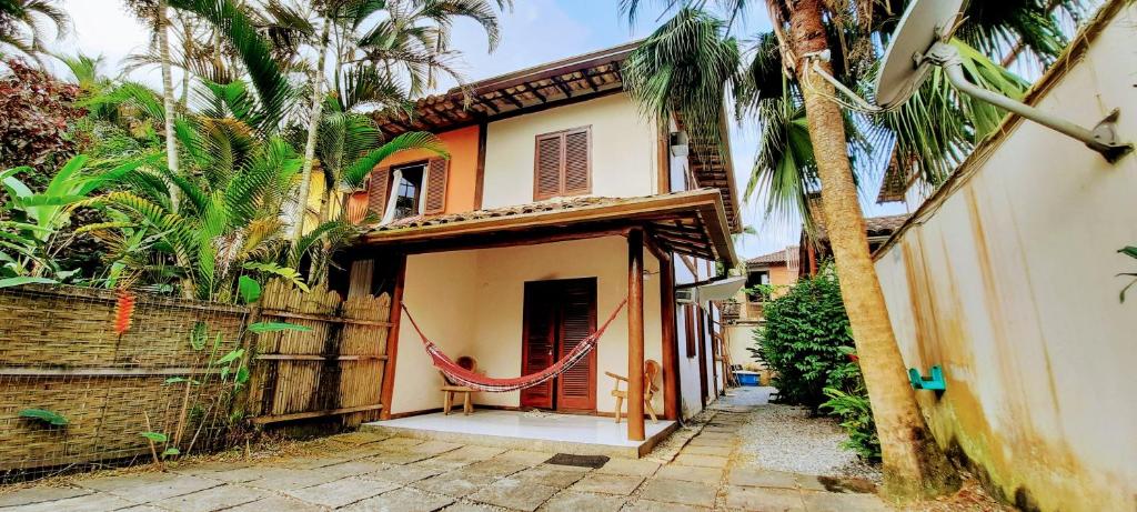 a house with a red door and palm trees at Casa Aconchegante - Com Passeio de Escuna de Cortesia! in Paraty