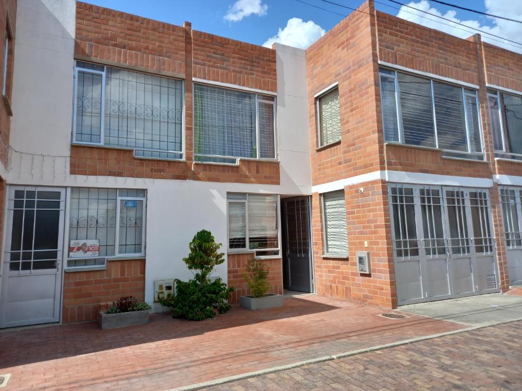 - un bâtiment en briques avec des fenêtres donnant sur une rue dans l'établissement La Estación es una casa amplia, central, cómoda, abrigada e integral en Paipa, à Paipa