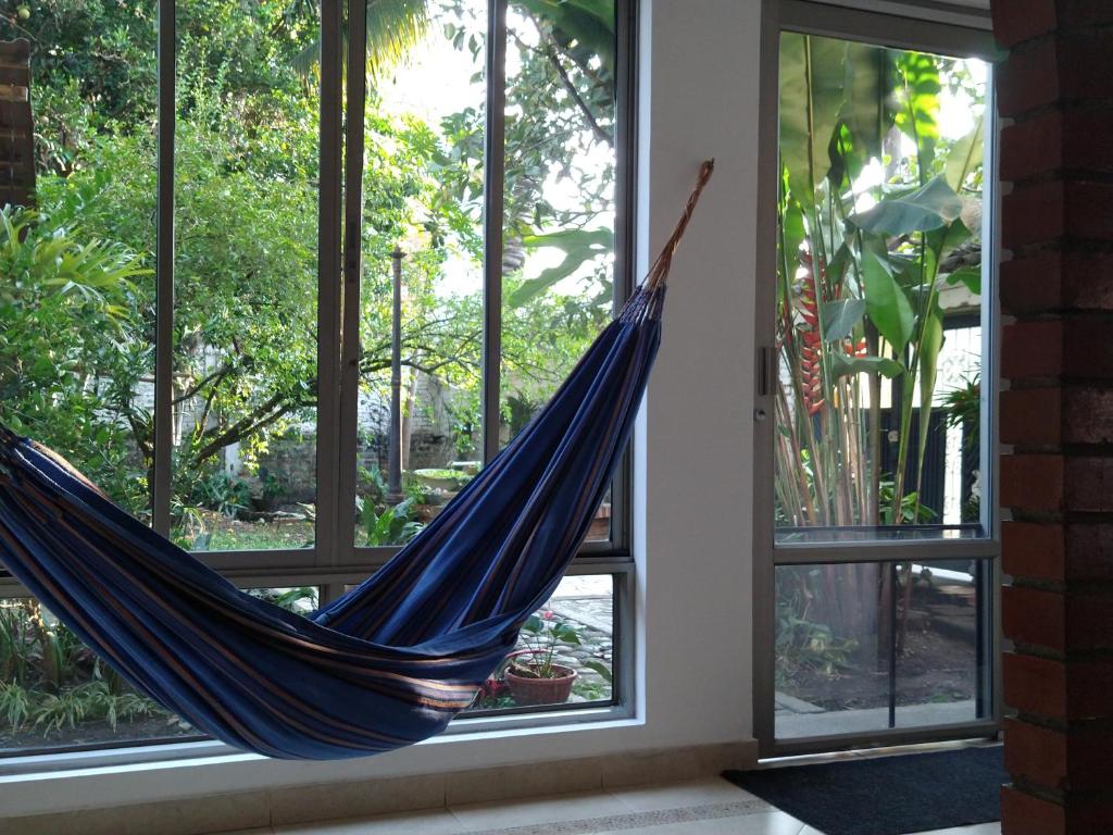 a hammock hanging in a room with windows at Pequeño Paraíso un lugar ventilado y acogedor in El Placer
