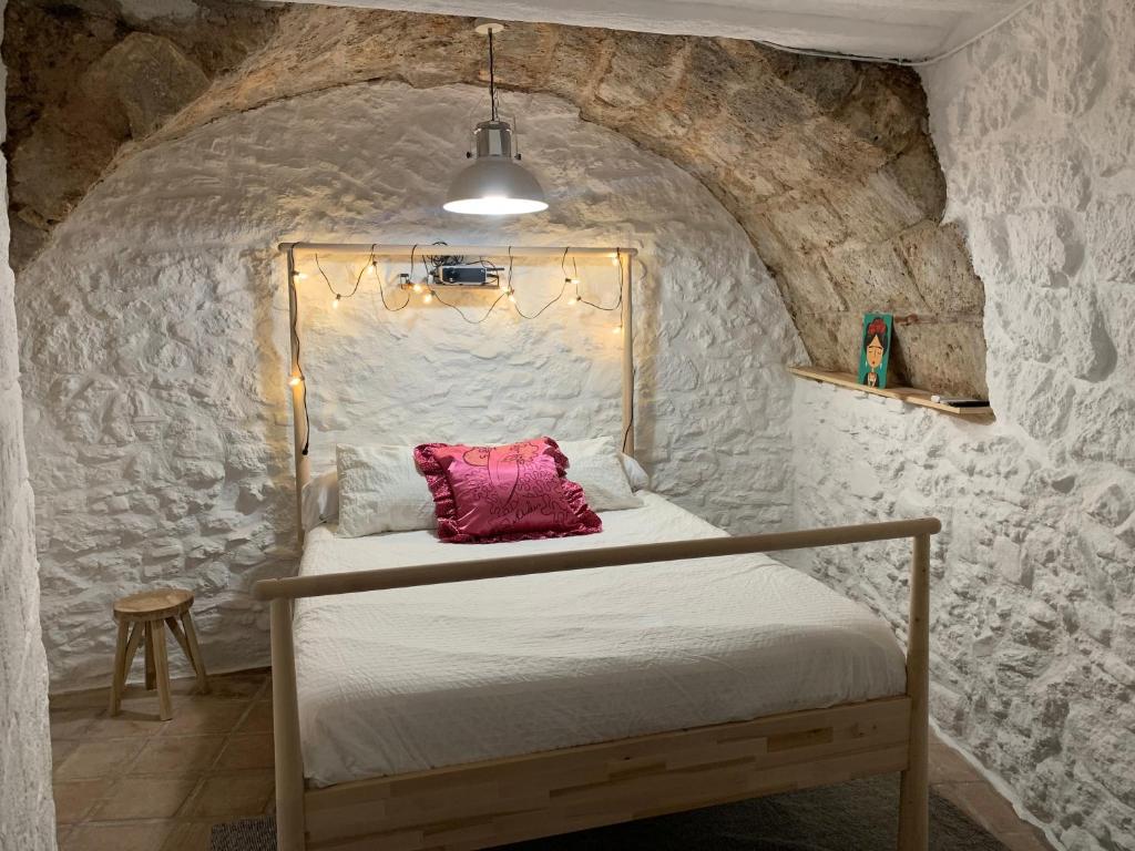 a bedroom with a bed in a stone wall at La Cueva de Alabama in Mijas