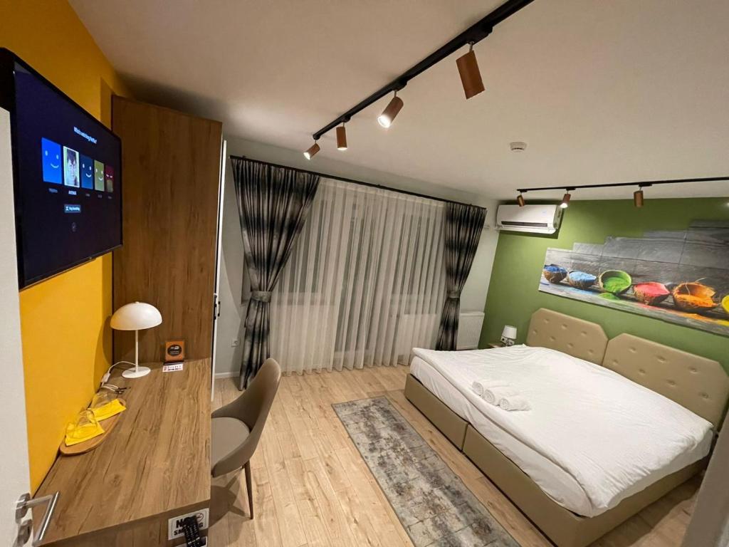 Avenue Apartment في بريشتيني: غرفة نوم فيها سرير وتلفزيون