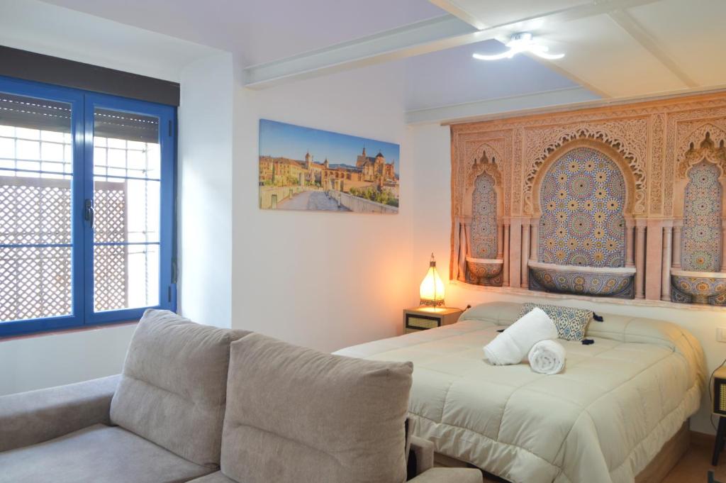 een slaapkamer met een bed en een bank bij ALCAZAR VIEJO PARKING Tourist Córdoba in Córdoba