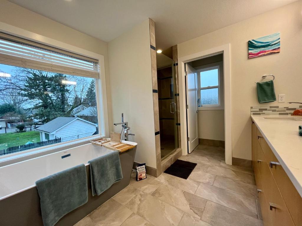 a bathroom with a tub and a sink and a window at Amorcito de Jenny - Shared House in Portland