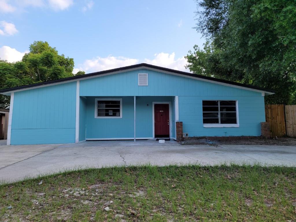 uma garagem azul com uma porta vermelha em Comfortable, Affordable Oasis in Altamonte Springs for a Couple or Family em Orlando