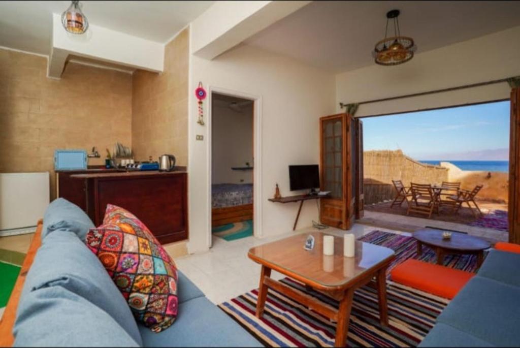 een woonkamer met een blauwe bank en een tafel bij Luna House Asala Beach in Dahab