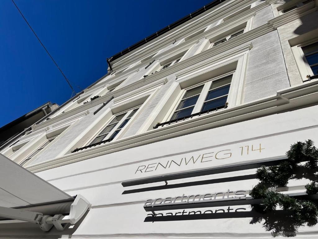a white building with a sign on the side of it at Rennweg 114 in Merano