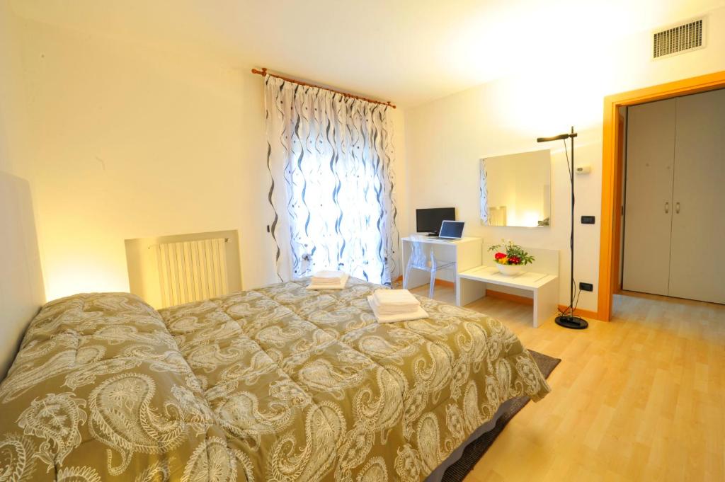 a bedroom with a bed and a window and a desk at Bed and Breakfast La Sosta in Ponte San Nicolo