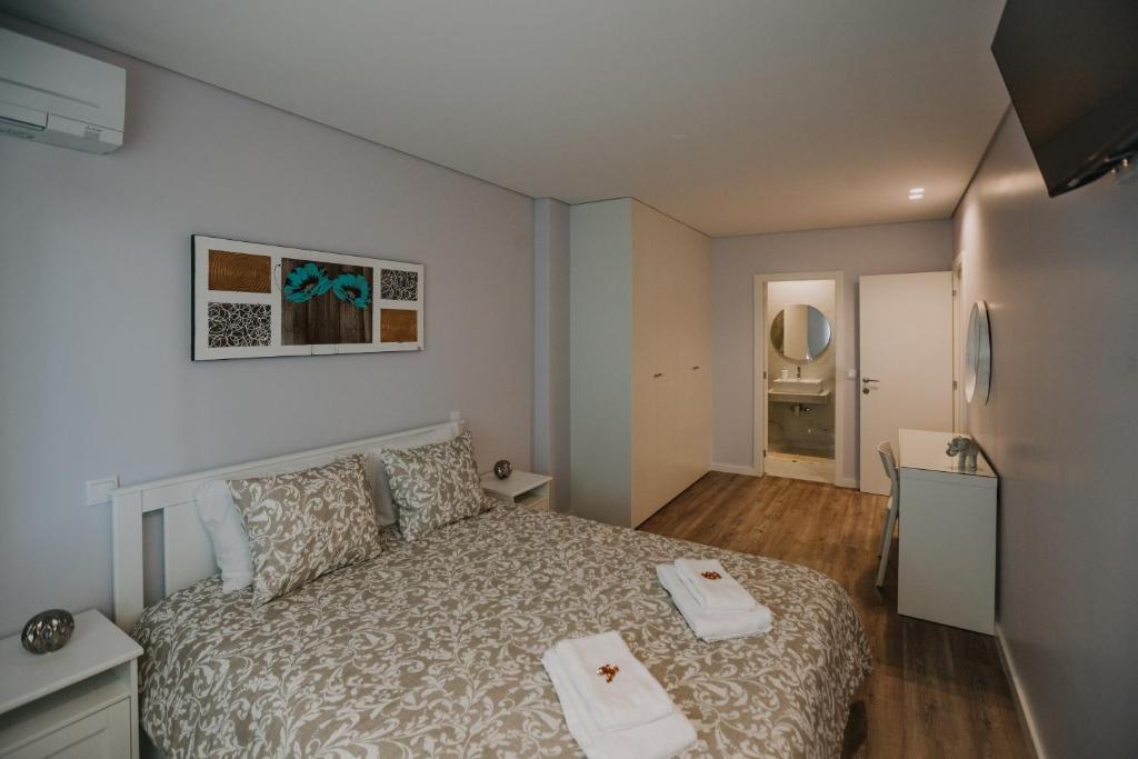 um quarto com uma cama com duas toalhas em Alojamento Amélie - Apartamento em Braga