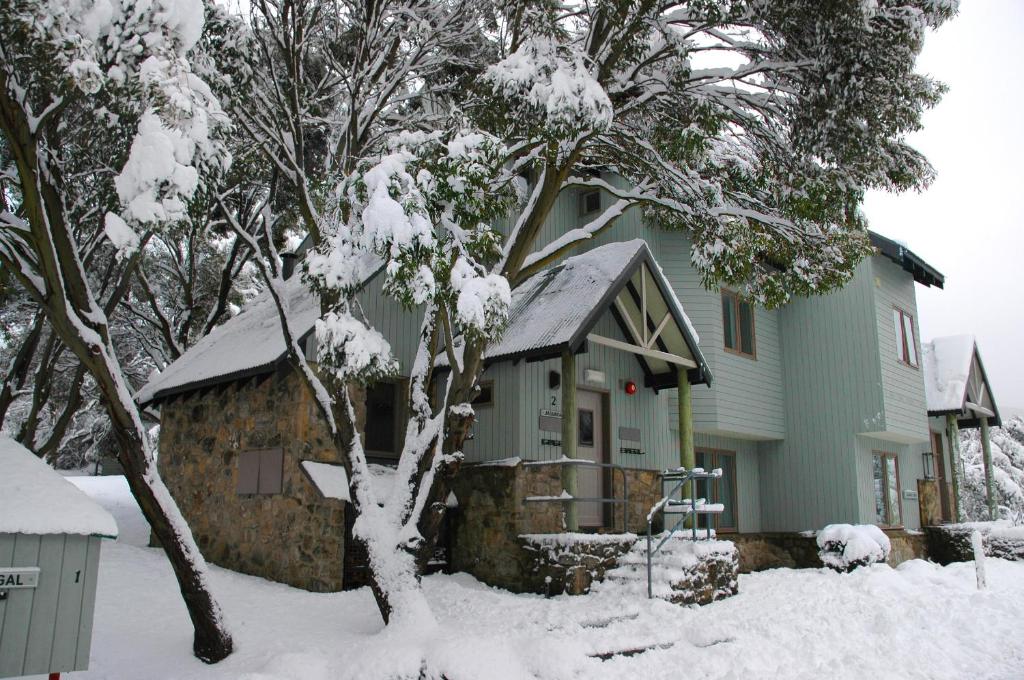 a house with snow on the roof of it at Jagungal in Thredbo