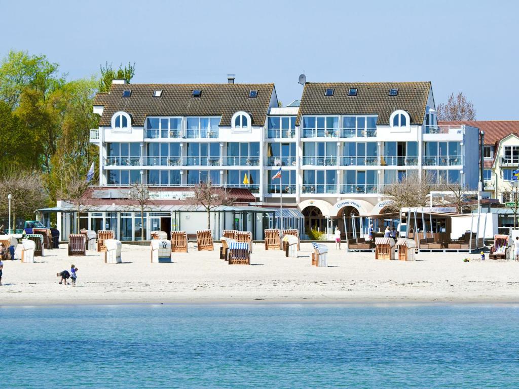 a large blue building on the beach next to the water at Ostsee-Hotel in Großenbrode