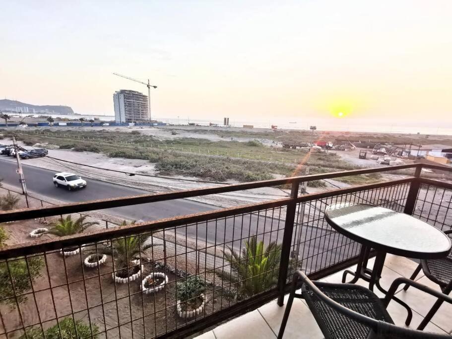 balcón con mesa y sillas y vistas a la playa en Departamento Vistamar 2 Puertas Pacifico, en Arica