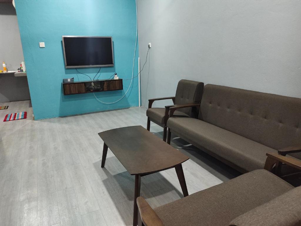 - un salon avec un canapé et une télévision dans l'établissement Alish Homestay Gua Musang with Free WiFi, Netflix, à Gua Musang