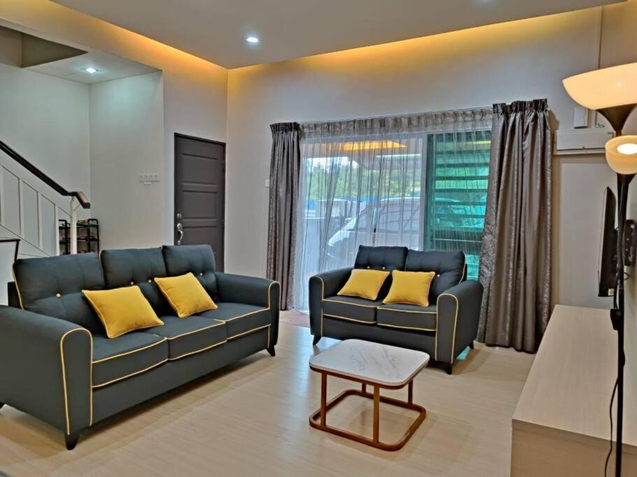 sala de estar con 2 sofás azules y almohadas amarillas en W13 atGoldenHills NightMarket WiFi 4R, en Brinchang
