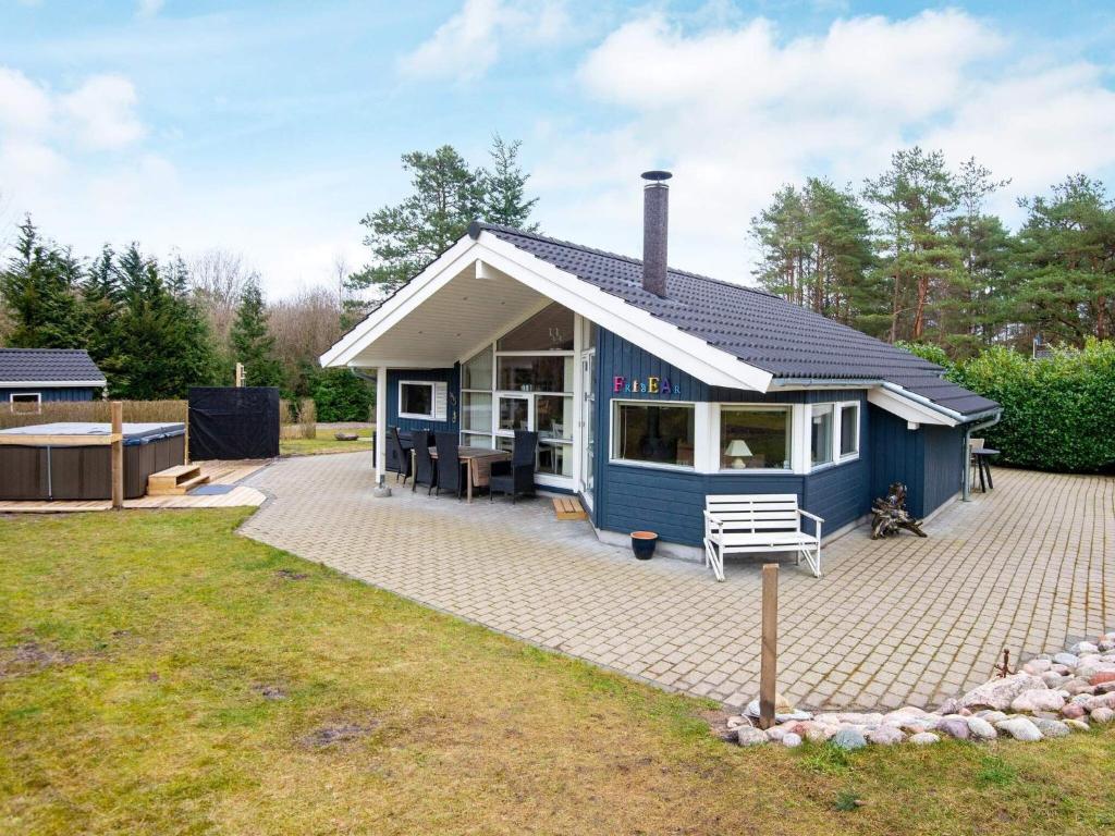 una pequeña casa azul con un gran patio en 8 person holiday home in Ebeltoft, en Ebeltoft
