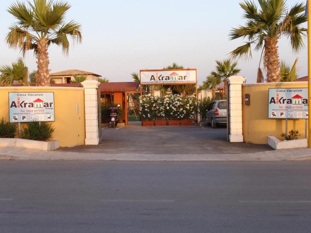a parking lot with palm trees in front of a hotel at Akramar Village in San Leone
