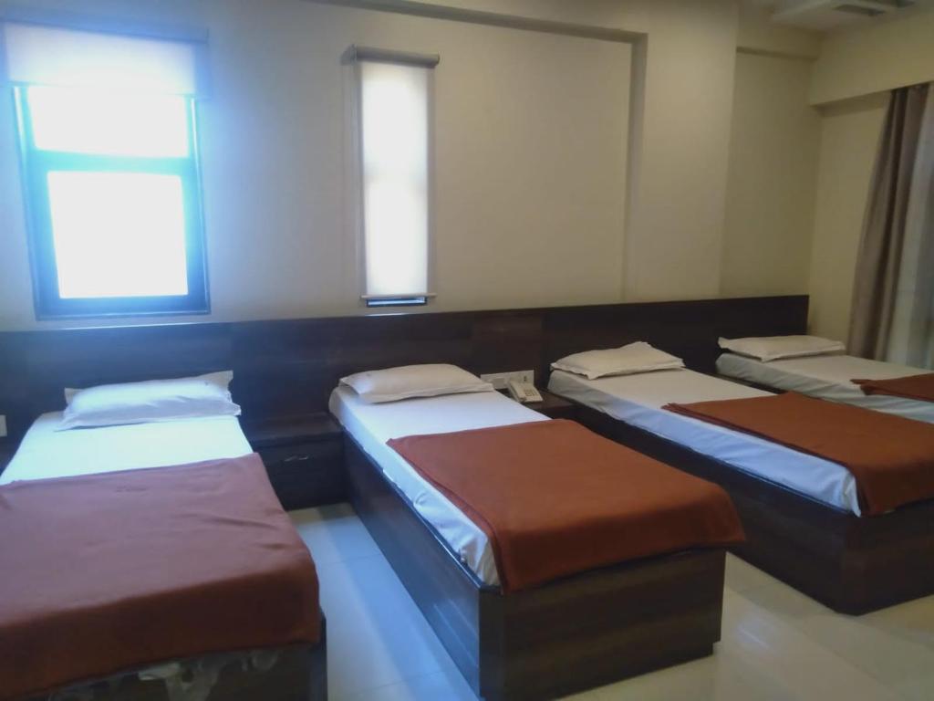 Postel nebo postele na pokoji v ubytování Sai Heera Residency Shirdi